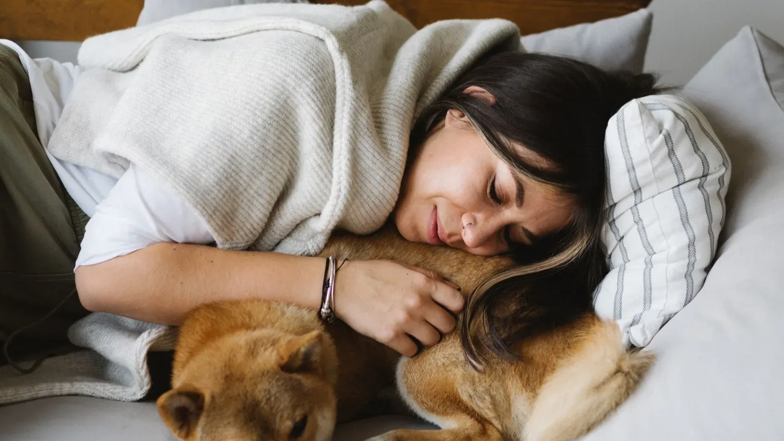 Hundägare som kramar sin hund i soffan